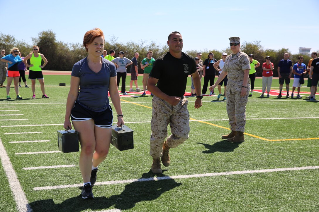 Amy C. Perkins, social studies teacher, Lakeshore High School, Stevensville, Mich., runs with ammunition cans during the Maneuver Under Fire portion of the Combat Fitness Test during Educators’ Workshop aboard the depot, April 8. Upon finishing the course, educators had a new outlook and understanding of the challenges recruits take on while in training.