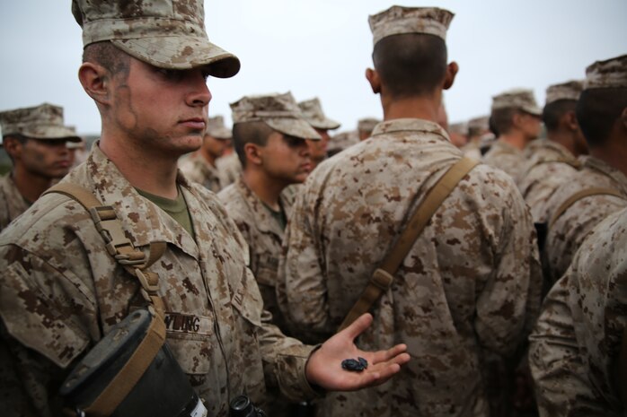 Pvt. Forest D. Dowling, Platoon 3271, Company M, 3rd Recruit Training Battalion, holds his newly earned Eagle, Globe and Anchor in the palm of his hand with pride after completing the Crucible, April 17. Dowling’s father and inspiration, Bill Dowling, Houston Fire Captain, lost both legs and suffered a brain injury due to a Southwest Inn fire that left four other firefighters dead.