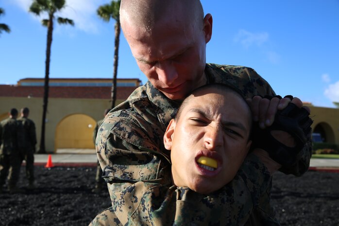 Pvt. David A. Bartel performs a figure four variation choke on Pvt. Troy A. Espinoza during thier Marine Corps Martial Arts Program test aboard the depot, April 2. Both Marines are members of Platoon 3275, Company M, 3rd Recruit Training Battalion.