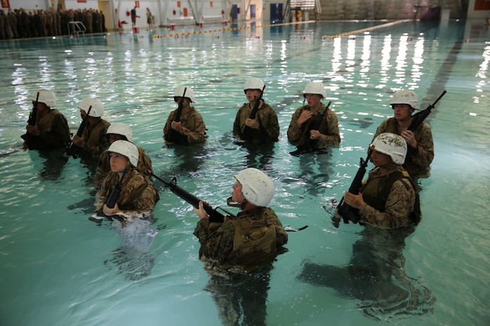 Recruits gear up with rubber rifles, flak jackets and helmets during water survival training aboard the depot, March 31. The Marine Corps is an amphibious fighting force, making it important for all recruits to learn basic water survival skills.