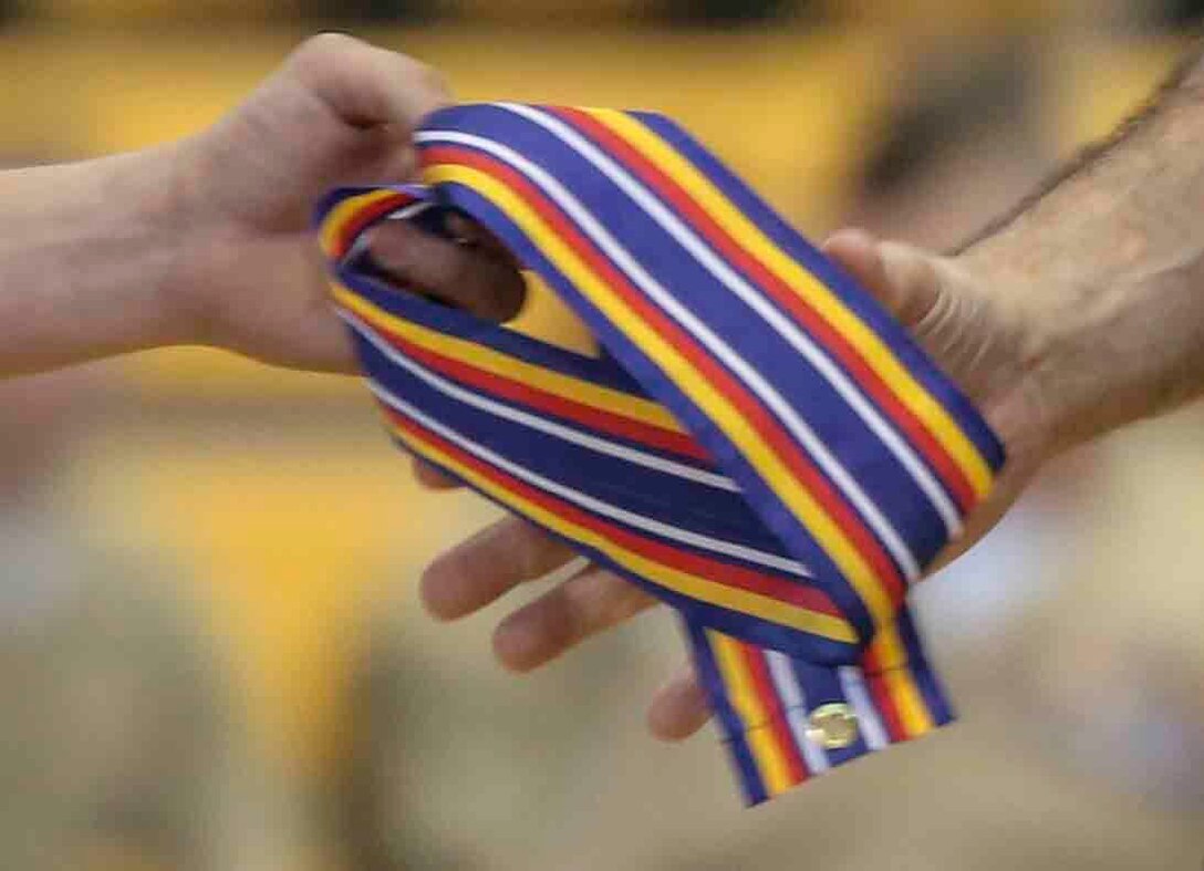 Colonel Clifford J. Weinstein, the commanding officer with 10th Marine Regiment, 2nd Marine Division, is handed the Global War on Terrorism service streamer during a battle color rededication ceremony April 25, 2014. The ceremony was held to celebrate the founding of the regiment, preserve the history of 10th Marines and to memorialize the regiment’s past through its present Marines and sailors.