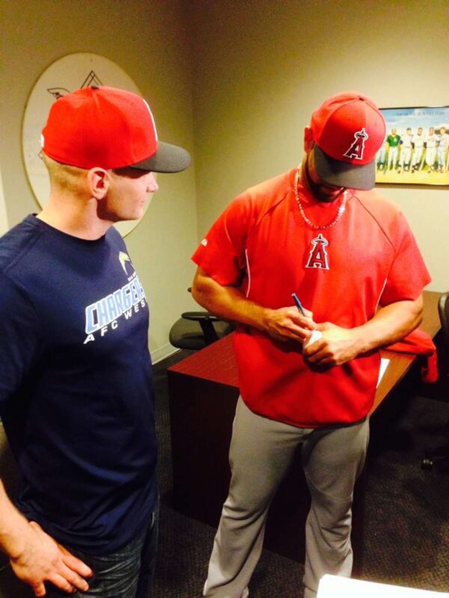 Albert Pujols signs a baseball for Staff Sgt. Thomas Sherrill after Sherrill caught and returned Pujols’ 500th career home run ball April 22, 2014, in Washington D.C. Sherrill, a long-time Angels fan, moved into the left-center field bleachers at Nationals Park shortly before Pujols' milestone at bat. (Courtesy photo/Angels Baseball) 