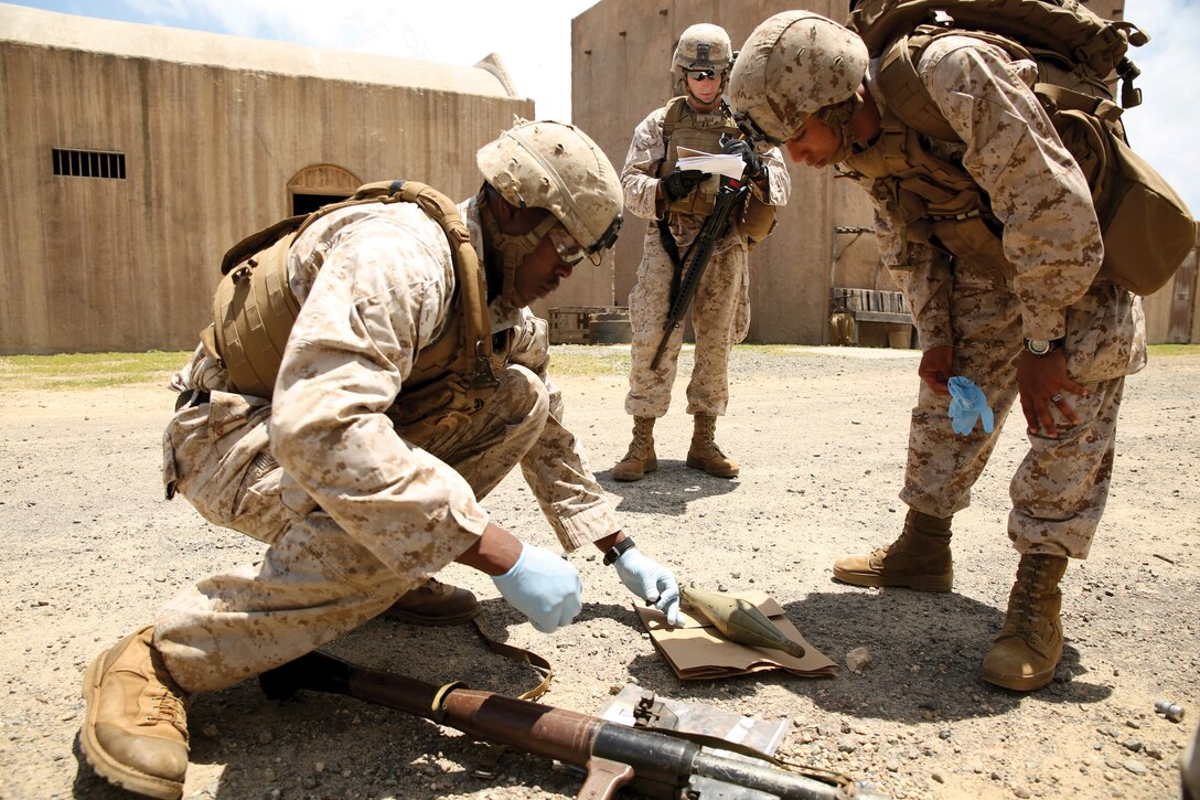 Marines participating in the Combat Hunter Trainer Course document evidence found in a military operations on urban terrain town during a tactical site exploitation exercise, April 23, 2014 at Marine Corps Training Area Bellows. (U.S. Marine Corps photo by Cpl. Sarah Dietz)