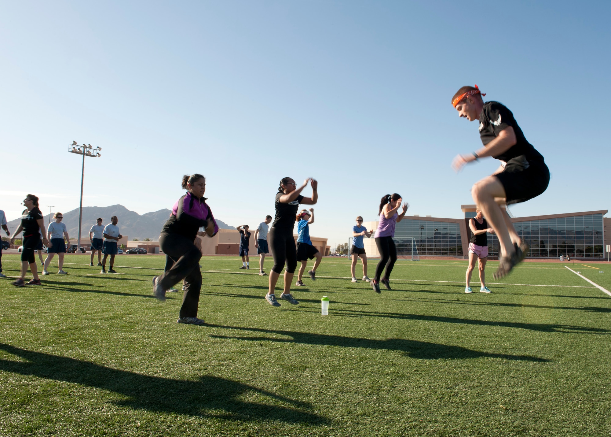 Staff Sgt. Jeff Golson, Nevada Test and Training Range NCOIC of range infrastructure, leads a group in jumping exercises during the Warrior Trained Fitness workout on the field behind the Warrior Fitness Center April 24, 2014, at Nellis Air Force Base, Nev. Military members and civilians in the Nellis community are encouraged to embrace the “Life of a Warrior” concept and live a healthy lifestyle. (U.S. Air Force photo by Airman 1st Class Thomas Spangler)