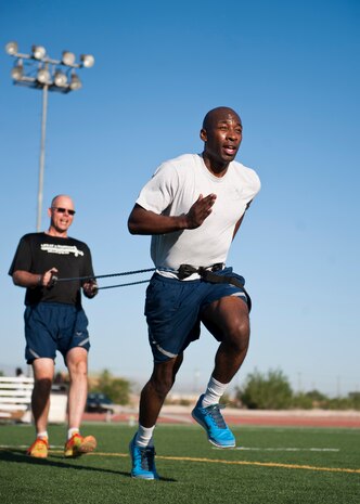 Senior Airman Terrence Dixon (front), 99th Security Forces Squadron commander support staff clerk, runs during the resistance portion of the Warrior Trained Fitness training session while being held by Master Sgt. Luke McCarthy, 99th SFS NCO in charge of range infrastructure, at the Warrior Fitness Center April 24, 2014, at Nellis Air Force Base, Nev. The WTF workout consisted of several stations which participants engaged in different exercises designed to increase cardio-vascular and muscular fitness. (U.S. Air Force photo by Airman 1st Class Thomas Spangler)
