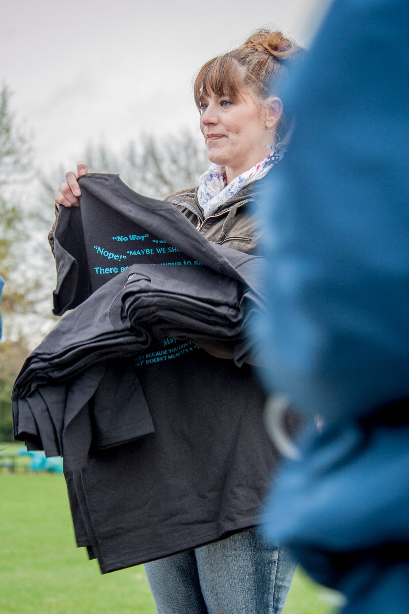 Dawn Altmaier hands out t-shirts to the first 300 runners to cross the finish line for the 1.5 mile Sexual Assault Awareness Month road race April 25, 2014, at Fairchild Air Force Base, Wash. Participants were given the option to run either 1.5 mile or 5k races. Nearly 500 Airmen, civilians and dependents came out in support of the event, that, as the wing leadership puts it, “builds respect and dignity across the wing and eradicates sexual assault in our unit.” Altmaier is the 92nd Air Refueling Wing community support coordinator. (U.S. Air Force photo by Staff Sgt. Benjamin W. Stratton/Released)