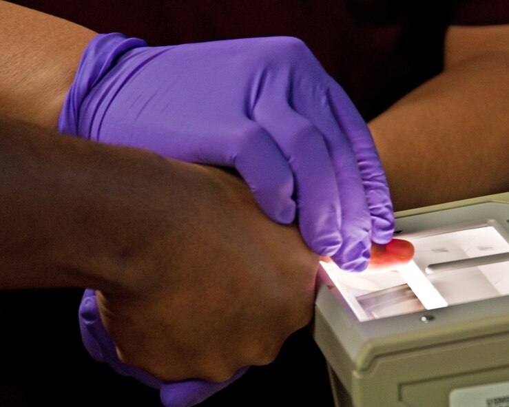 A processing applicant undergoes a criminal background bio-metric finger print screening April 1, 2014, at the Sacramento Military Entry Processing Station. All processing for military service is accomplished in the MEPS, starting with bio-metric finger print enrollment, medical examinations, criminal background screening, testing and job selection, culminating the day with the Oath of Enlistment. (U.S. Air Force photo by Senior Airman Charles V. Rivezzo)