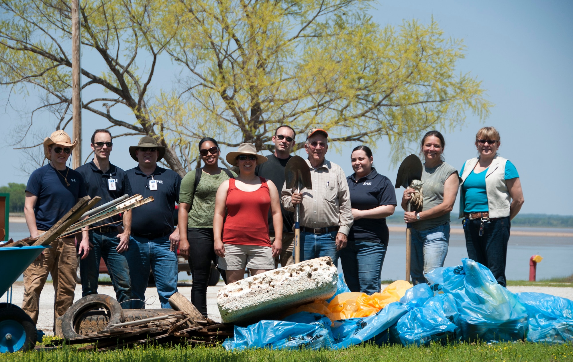 Volunteers from Sheppard Air Force Base, Texas, stand behind the bags of trash and debris they removed from the shoreline, April 22, 2014. The volunteers participated in an Earth Day clean-up event aimed at ridding the beach of hazardous objects and litter exposed by the low water levels. (U.S. Air Force photo/Airman 1st Class Robert L. McIlrath)