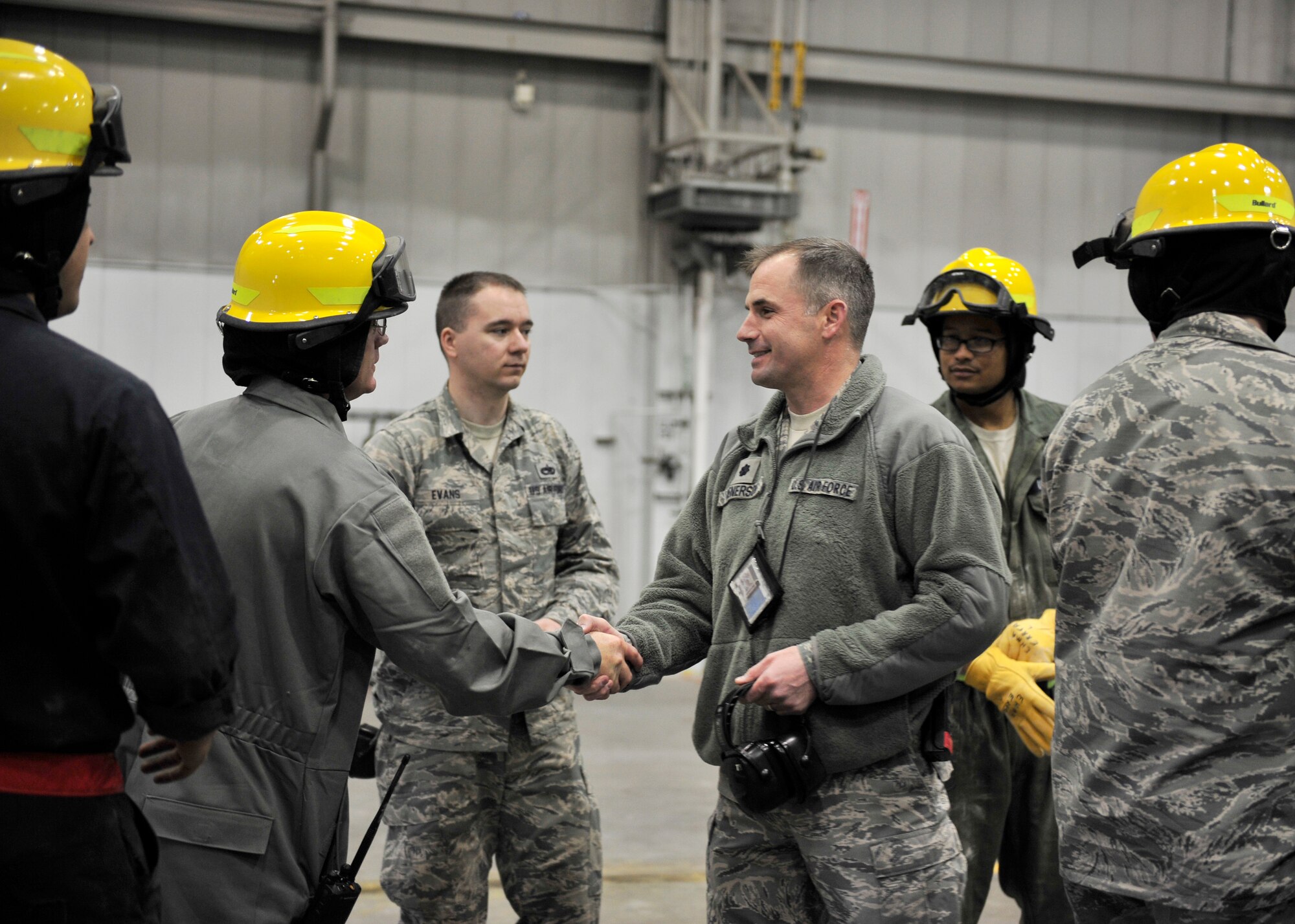 Lt. Col. Barton Kenerson, 354th Maintenance Group deputy commander, shakes hands with members from the crash recovery team April 23, 2014, Eielson Air Force Base, Alaska. Kenerson, along with other base officials, observed how the crew performed in simulating lifting an F-16 Fighting Falcon assigned to the 18th Aggressor Squadron for an operational readiness exercise. (U.S. Air Force photo by Senior Airman Ashley Nicole Taylor/Released)