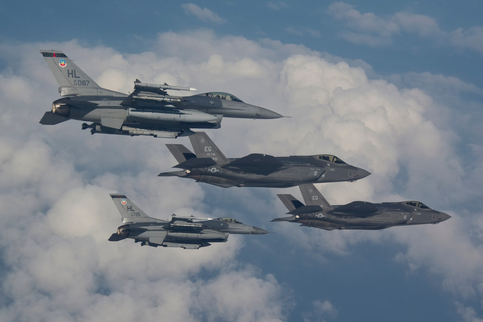 F-16s from Hill Air Force Base fly next to the F-35A Lightning II, the Air Force’s newest fighter jet, in a training mission at Eglin AFB, Fla., Thursday. Hill AFB is slated to receive its first operational F-35s in the fall of 2015. (U.S. Air Force photo/Staff Sgt. Katerina Slivinske)
