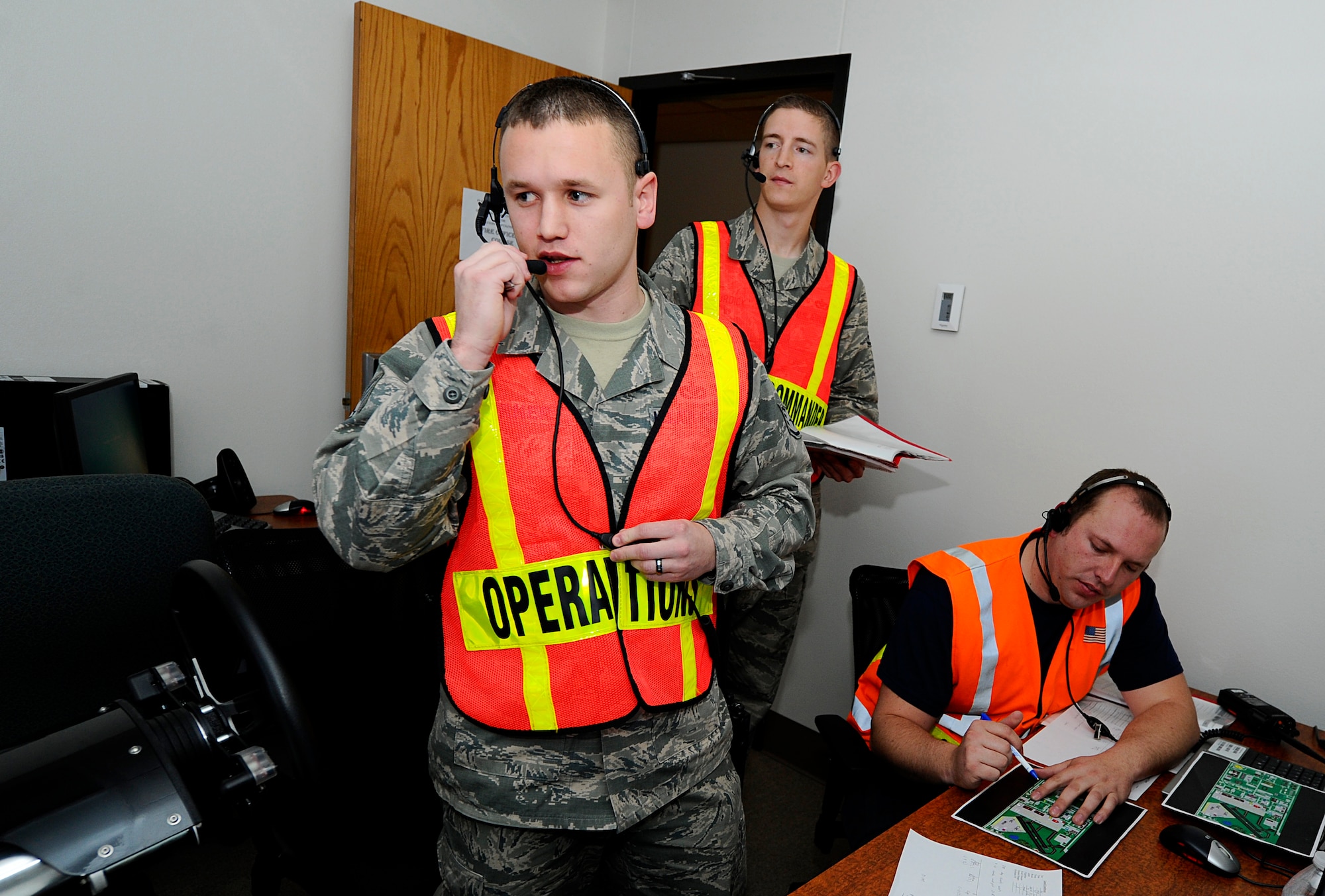 Staff Sgt. William Turner, 22nd Civil Engineer Squadron lead firefighter crew chief, coordinates with a fire crew over the radio during a mass-casualty exercise, April 17, 2014, at McConnell Air Force Base, Kan. The firefighters were part of a virtual fire simulation class that provides a realistic environment to train in without using an actual fire. (U.S. Air Force photo/Airman 1st Class Victor J. Caputo)