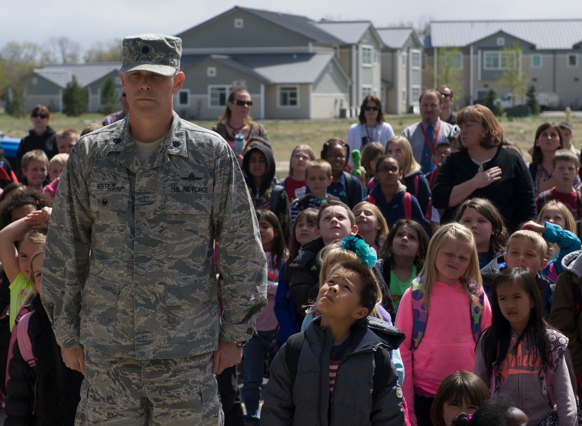 U.S. Air Force Lt. Col. Larry Estes, 366th Mission Support Group deputy commander, stands at the position of attention during the Pledge of Allegiance, April 23, 2014, at Mountain Home Air Force Base, Idaho. Estes presented a flag, which was flown over Afghanistan, to the Base Primary School to hang on the newly installed flag pole. (U.S. Air Force photo by Airman 1st Class Brittany A. Chase/Released)
