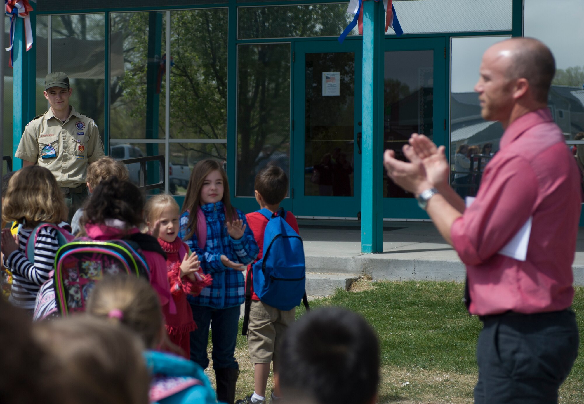 Children from the Mountain Home Air Force Base Primary School applaud Josh Meyers, senior patrol leader for Boy Scout troop 102, during an assembly, on April 23, 2014, at Mountain Home Air Force Base, Idaho. Meyers took on the challenge as his Eagle Scout project, which included all efforts to make the flag pole happen. (U.S. Air Force photo by Airman 1st Class Brittany A. Chase/Released)