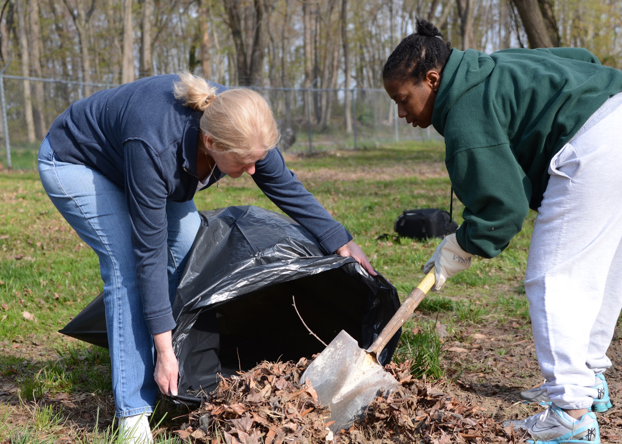 Debbie Willders (left), 175th Comptroller Flight, and U.S. Air Force Tech. Sgt. Alonda Foster, 175th Comptroller Flight, bag up leaves April 25, 2014 during Base Beautification Day at Warfield Air National Guard Base, Baltimore, Md. Base Beautification Day gives members of the 175th Wing the opportunity to improve the cleanliness and aesthetics of their outside work areas.  (U.S. Air National Guard photo by Tech. Sgt. Chris Schepers/RELEASED)