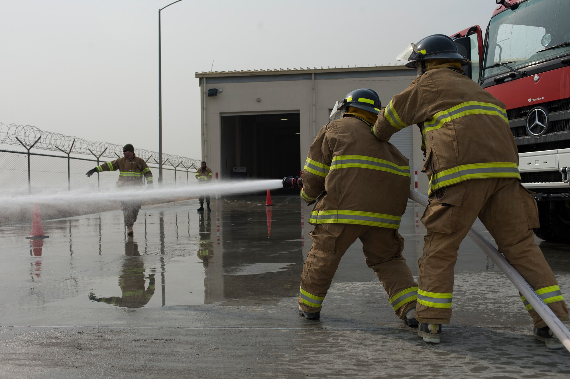 Master Sgt. Jeffery Hackworth, 438th Air Expeditionary Wing/NATO Air Training Command-Afghanistan firefighting advisor, far left, helps Afghan air force firefighters respond to a training scenario, Feb. 23, 2014, Kabul International Airport, Kabul, Afghanistan. Hackworth, a Jackson, Mich. native, is deployed from the 10th Civil Engineering Squadron, U.S. Air Force Academy, Colorado Springs, Colo. Airmen of the 438th AEW/NATC-A play a vital role in Operation Enduring Freedom as advisors tasked with aiding the Afghan government in establishing an operational and sustainable Afghan air force. (U.S. Air Force photo by Tech. Sgt. Jason Robertson/Released)