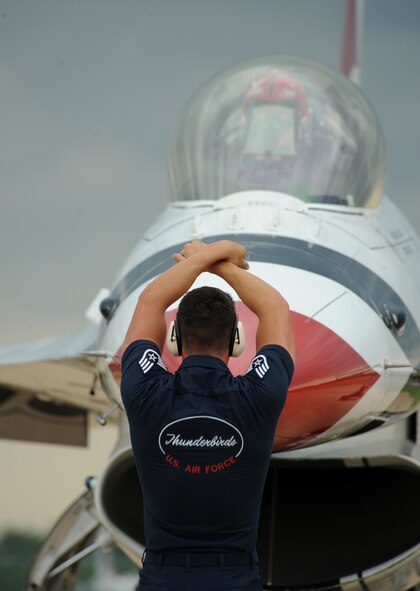 A U.S. Air Force Thunderbirds crew chief directs an F-16 Fighting Falcon into a parking spot on Barksdale Air Force Base, La., April 24, 2014. The 2014 Defenders of Liberty Air Show will feature several aerial demonstration acts, headlined by the Thunderbirds. (U.S. Air Force photo/Senior Airman Benjamin Gonsier)