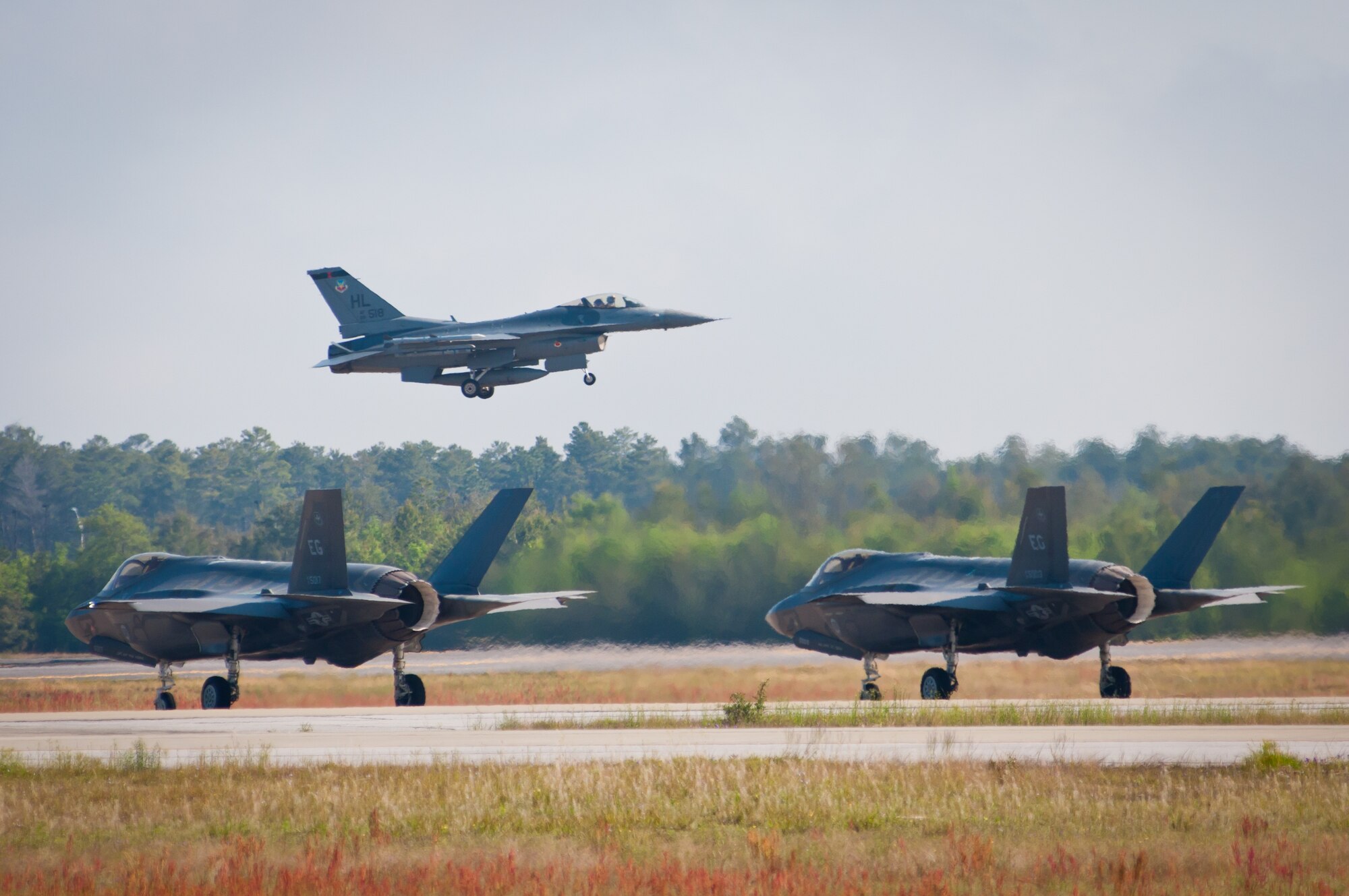 An F-16 Fighting Falcon takes off while two F-35 Lightning IIs taxi during a training mission April 24, 2014, at Eglin Air Force Base, Fla. F-16s from the 419th and 388th Fighter Wings from Hill AFB, Utah, conducted their first training missions alongside the Air Force’s newest fighter aircraft. (U.S. Air Force photo/Staff Sgt. Christina Judd) 
