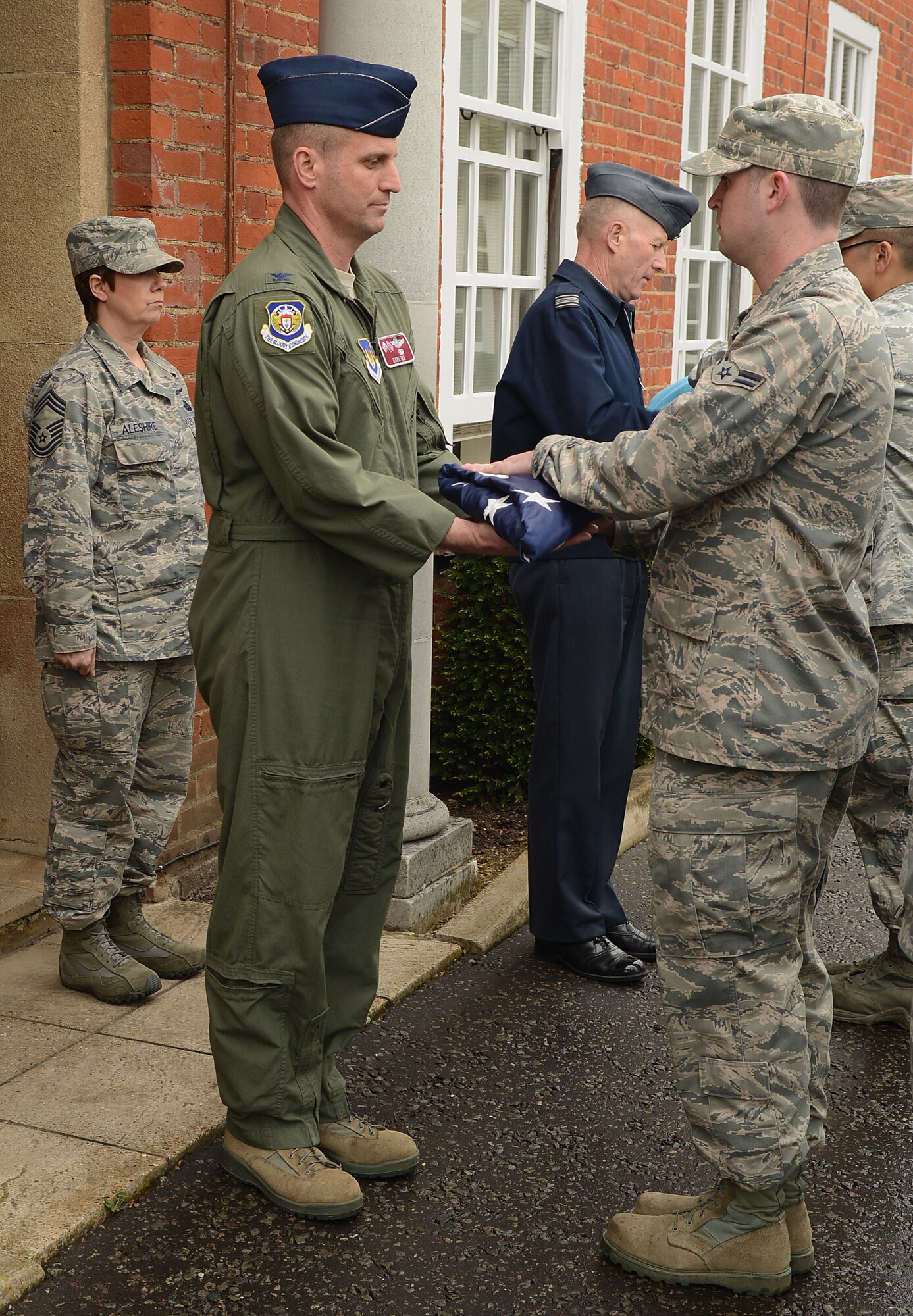 U.S. Air Force Col. David Cox, left, 100th Air Refueling Wing vice commander, receives the U.S. flag from flag detail after a retreat ceremony April 25, 2014, on RAF Mildenhall, England. Retreat is a long-standing tradition honoring the flag and indicating the end of the duty day. (U.S. Air Force photo by Airman 1st Class Jonathan Light/Released)