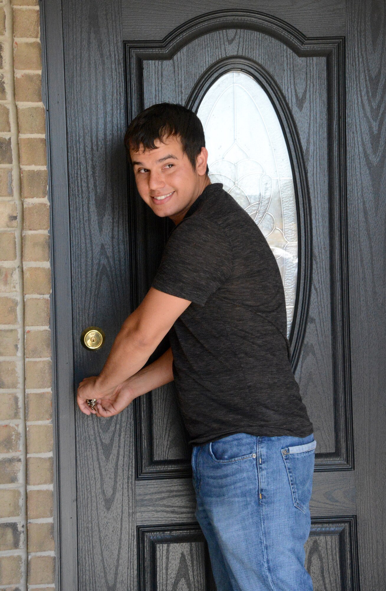 Nicholas Henthorn, who works in aircraft hydraulics with the 552nd Commodities Maintenance Squadron, turns the key to his new house in Moore during an April 4 dedication ceremony presented by the Central Oklahoma Habitat for Humanity. Mr. Henthorn's home was destroyed by the May 20 F5 tornado last year. (Air Force photo by Kelly White)