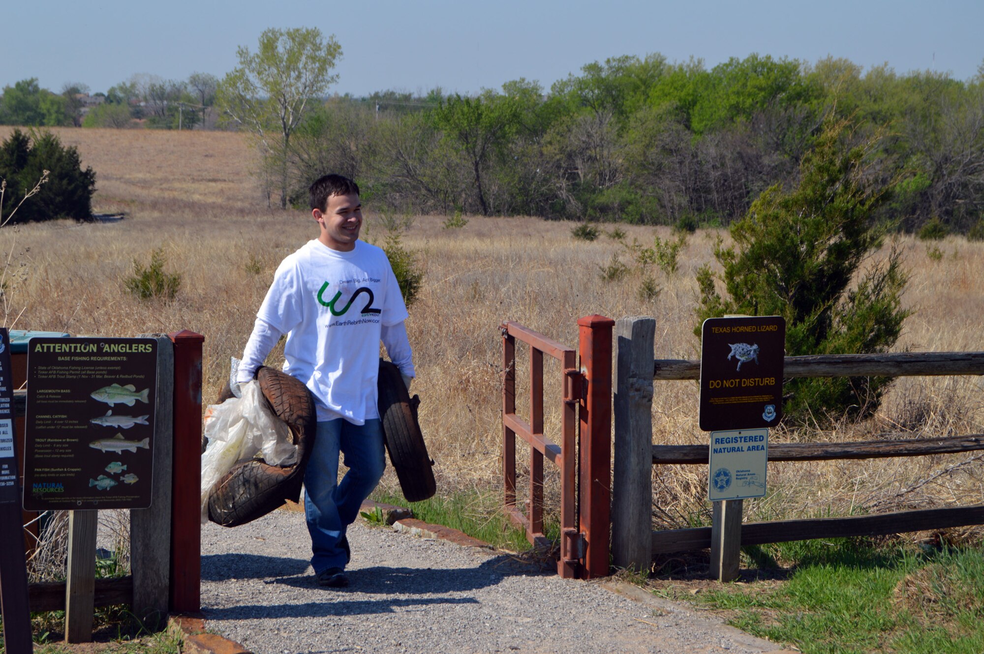 Blake Mangum, with Earth Rebirth, hauls tires he found to the dumpster. Among other items found during the April 18 Urban Greenway trash cleanup event were a tent and sleeping bag, a teapot, a frying pan and a chair. Much of what was found was recyclable, such as plastic bottles, paper items, Styrofoam cups, plastic bags and cans. (Air Force photo by April McDonald)