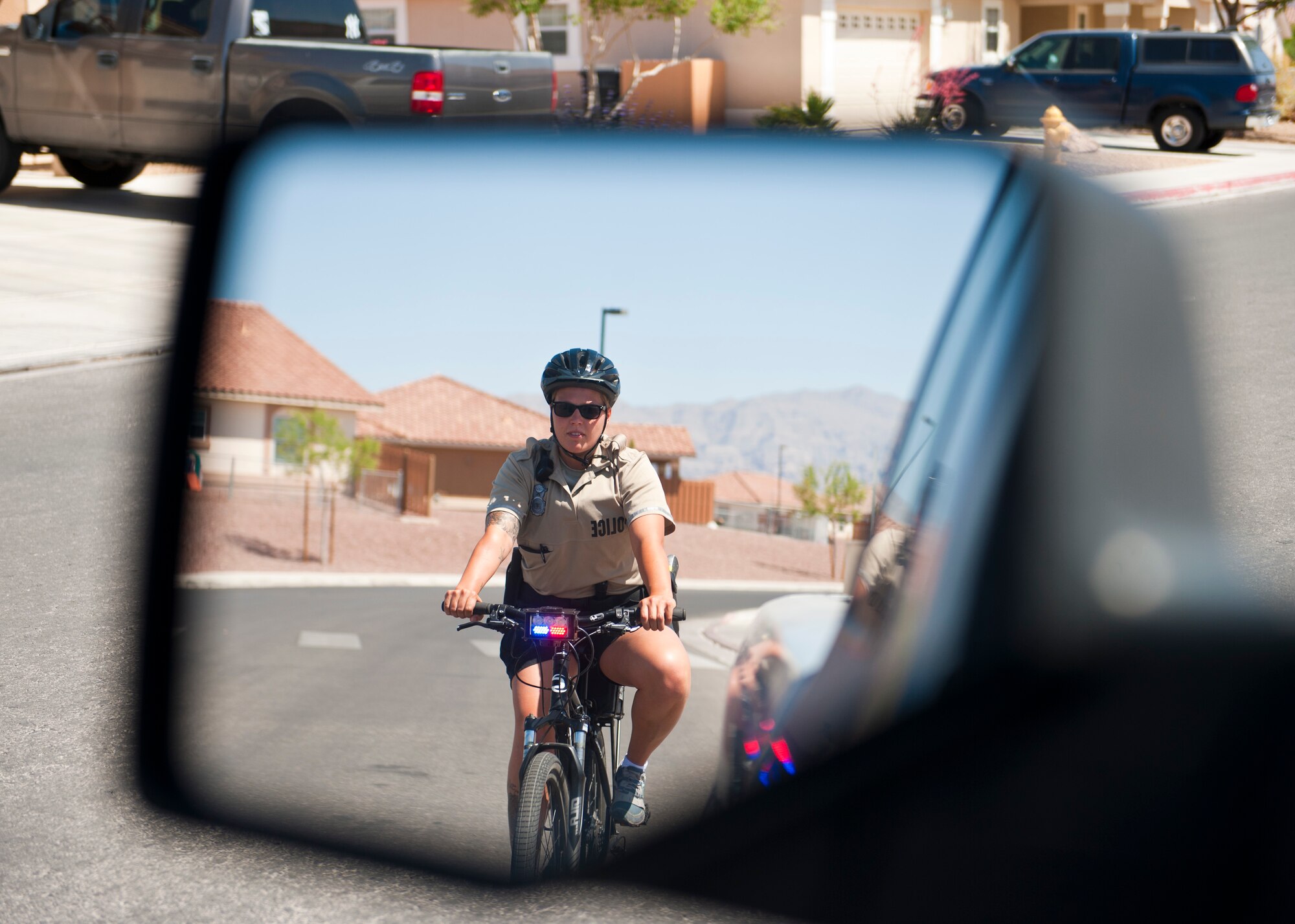 Senior Airman Audrey Lorenson, 99th Security Forces Squadron patrolman, practices approaching a stopped vehicle near base housing April 23, 2014, at Nellis Air Force Base, Nev. With a $10,000 grant from the 99th Civil Engineer Squadron, the 99th SFS was able to provide upgrades to their bicycles including flashing lights and sirens which will aid the patrolmen in pulling over vehicles and making the area aware of their presence. (U.S. Air Force photo by Airman 1st Class Thomas Spangler)