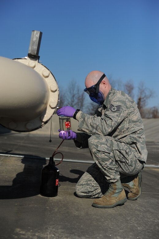 Staff Sgt. David Harris, 87th Logitics Rediness Squadron Fuels Lab NCO in charge, collects JP-8 fuel from a pipeline to analyze at the Fuels Lab Jan. 17, 2014, at Joint Base McGuire-Dix-Lakehurst, N.J. He analyzed the fuel to ensure the amount of dissolved solids in the fuel did not fall outside of acceptable parameters set by Air Force standards for fuel. (U.S. Air Force photo by Airman 1st Class Sean M. Crowe/Released)