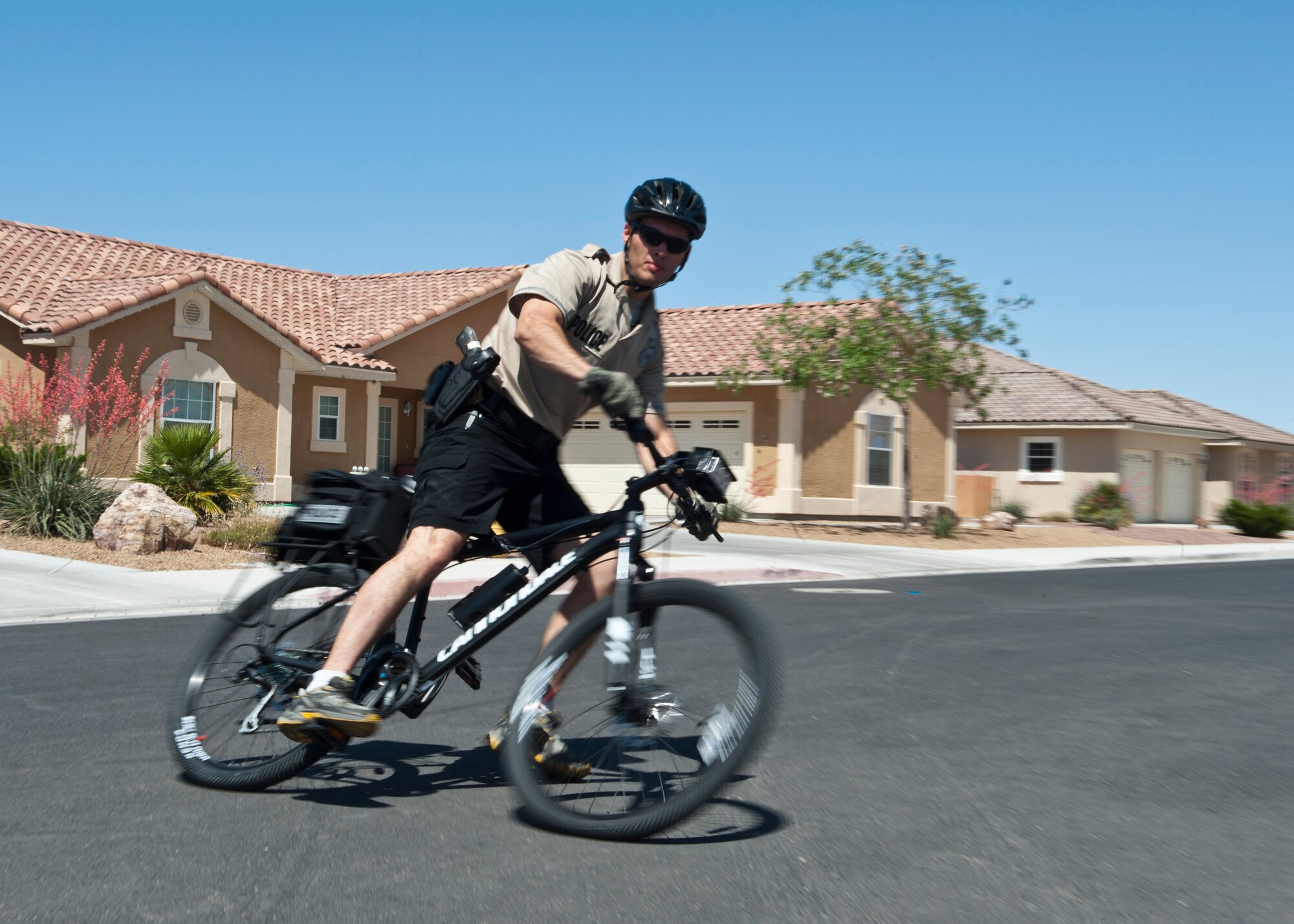 Staff Sgt. Jordan Young, 99th Security Forces Squadron training instructor, practices a power-slide breaking maneuver near base housing April 23, 2014, at Nellis Air Force Base, Nev. The 99th SFS is patrolling the hospital side of base housing neighborhoods on bicycles. In addition to making the patrolmen more approachable and personable, patrolling on bicycles gives patrolmen the ability to quickly move through areas that motor vehicles cannot, such as parks and playgrounds. (U.S. Air Force photo by Airman 1st Class Thomas Spangler)