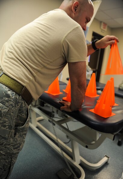 U.S. Air Force Master Sgt. Brandon Livingston, 23d Civil Engineer Squadron explosive ordnance disposal superintendent of logistics, holds his self up using the arm he recently had surgery on at Moody Air Force Base, Ga., April 23, 2014. This exercise is designed to help Livingston regain strength and muscle control. (Airman 1st Class Alexis Millican/Released)  