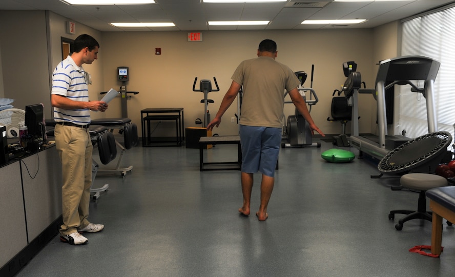 Valdosta State University’s Sean Amos, senior athletic training student, left, watches U.S. Air Force Senior Airman Chris Kingsbury, 23d Medical Support Squadron diagnostic imaging technician, walk heel to toe down a line at Moody Air Force Base, Ga., April 23, 2014. Walking heel to toe is a physical therapy method used to improve balance and stability. (Airman 1st Class Alexis Millican/Released)  