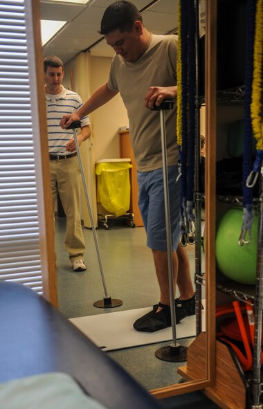 Valdosta State University’s Sean Amos, senior athletic training student, left, instructs U.S. Air Force Senior Airman Chris Kingsbury, 23d Medical Support Squadron diagnostic imaging technician, to slide his feet back and forth during a physical therapy exercise at Moody Air Force Base, Ga., April 23, 2014. Athletic training students from Valdosta State University must complete an internship every semester; Moody’s physical therapy is just one of many options available to them. (Airman 1st Class Alexis Millican/Released)