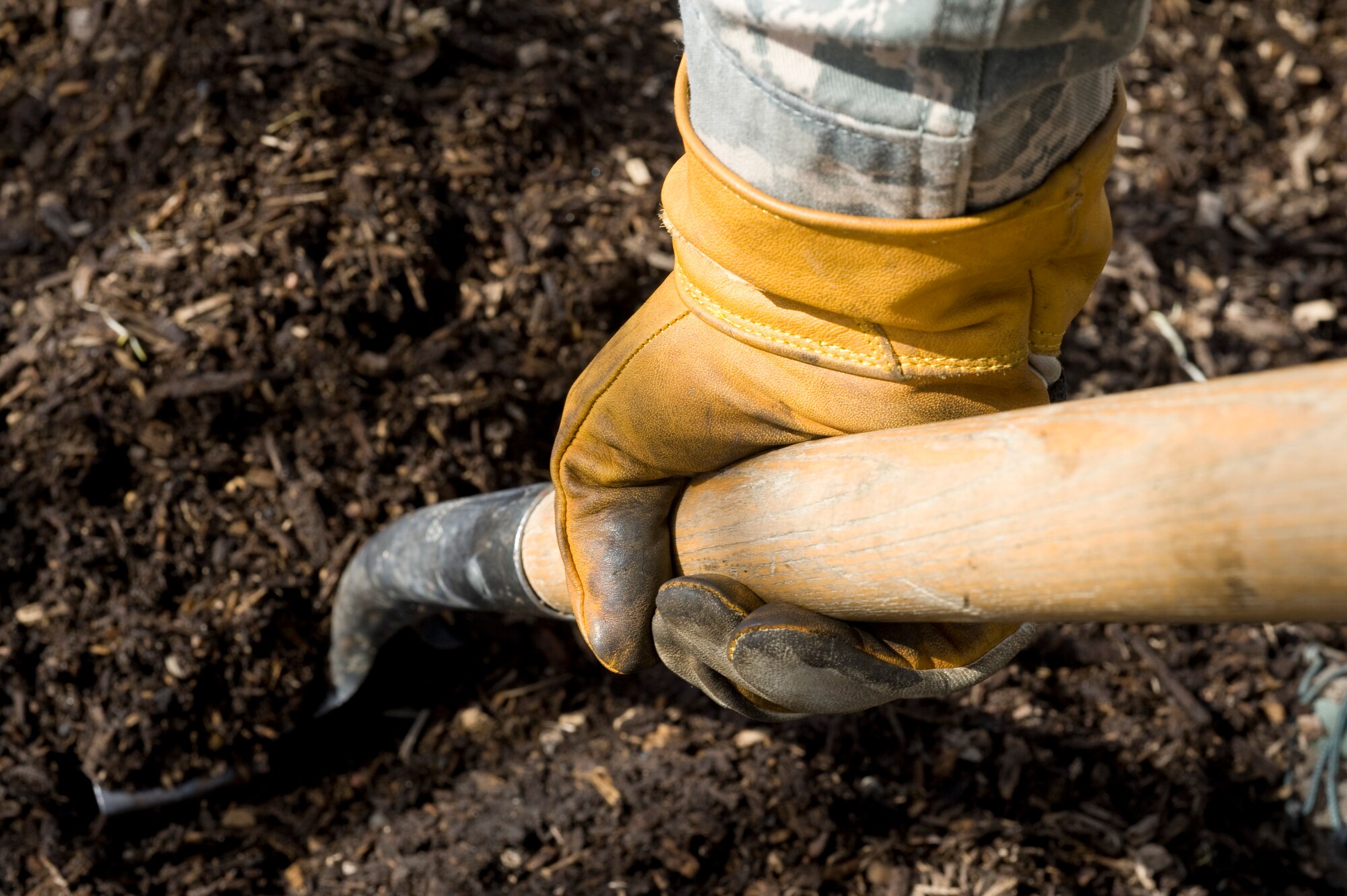 An Airman from the 5th Civil Engineer Squadron shovels mulch during Earth Day at Minot Air Force Base, N.D., April 21, 2014. Airmen from across the base cleaned up base parks, picked up trash and completed other projects to beautify the base and take care of the environment. (U.S. Air Force photo/Senior Airman Malia Jenkins) 