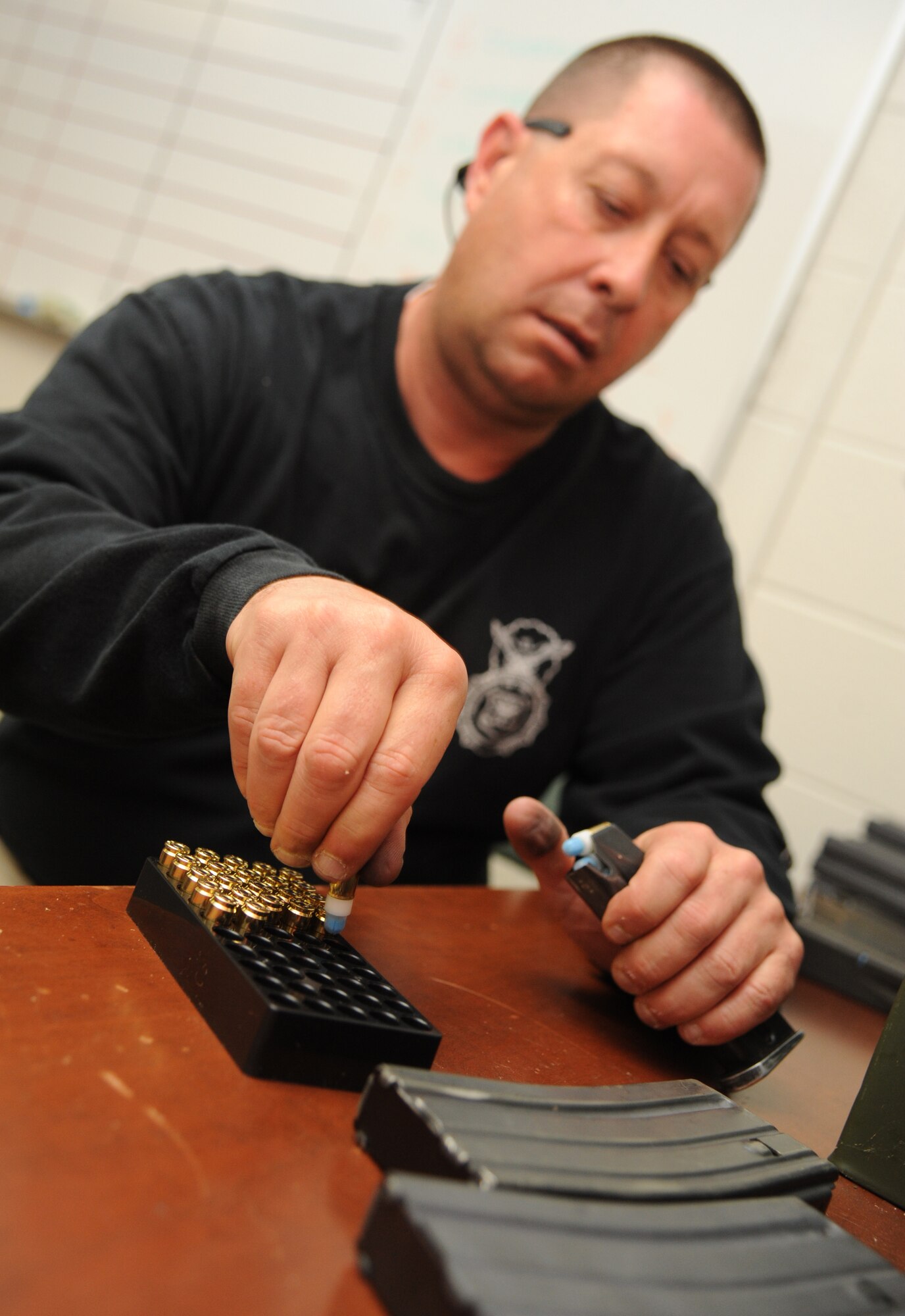 Staff Sgt. Lee Kinchen, 81st Security Forces Squadron combat arms instructor, reloads a magazine with ammunition for trainees as they go through various scenarios simulating real-world conditions for an 81st SFS active shooter training April 23, 2014, at The Locker House, Keesler Air Force Base, Miss.  The two-day annual training prepares the SF Airmen to react during real-world situations.  (U.S. Air Force photo by Kemberly Groue)
