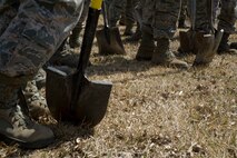 Airmen from the 5th Civil Engineer Squadron stand with rakes and shovels preparing to spread mulch at a playground during Earth Day on Minot Air Force Base, N.D., April 21, 2014. Airmen from across the base cleaned up base parks, picked up trash and completed other projects to beautify the base and take care of the environment. (U.S. Air Force photo/Senior Airman Malia Jenkins)