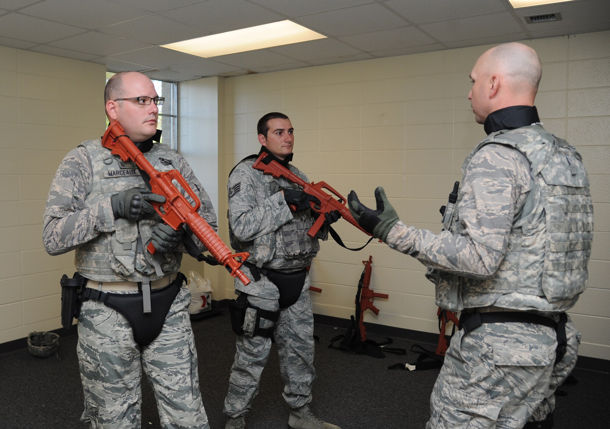 Staff Sgts. Louis Marceaux and Sean Neri, 81st Security Forces Squadron, receive instruction from Tech. Sgt. Joshua Reese, 81st SFS, during an 81st SFS active shooter training session April 23, 2014, at The Locker House, Keesler Air Force Base, Miss.  The two-day annual training prepares the SF Airmen to react during real-world situations.  (U.S. Air Force photo by Kemberly Groue)