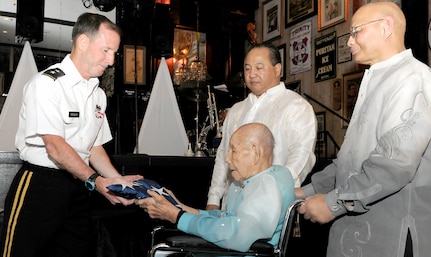 Maj. Gen. Joseph P. DiSalvo (left), U.S. Army South commanding general, presents a U.S. flag to retired 1st Lt. Justo Dumlao (seated) as Dumlao’s sons Fred (second from right) and Robert look on at the Old San Francisco Steakhouse April 11.
Photos by Robert R. Ramon