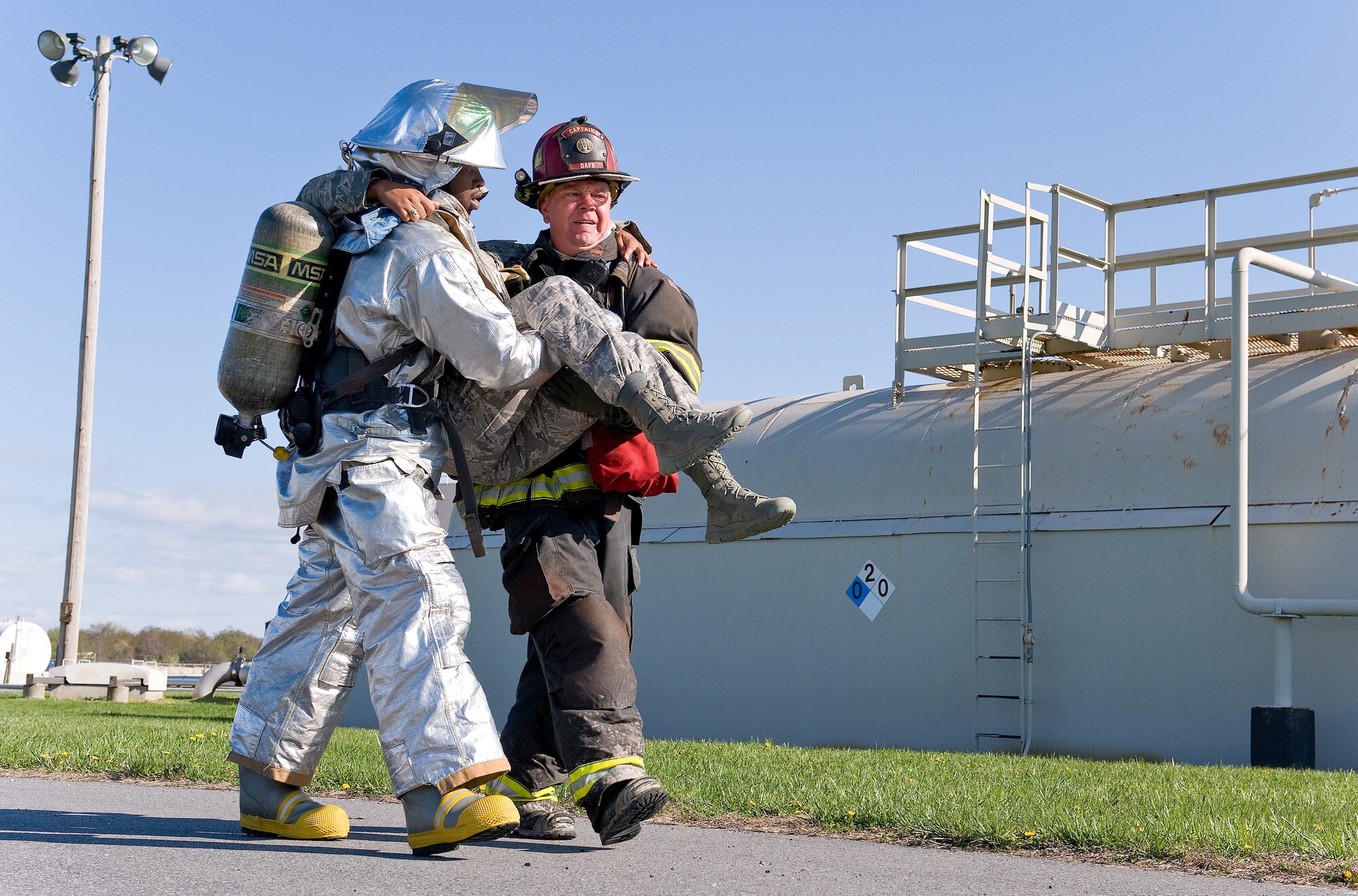 Senior Airman Dequan Griffin, left, a fire protection apprentice with the 459th Civil Engineer Squadron Fire Department, Joint Base Andrews, Md., and Aaron Weisenberger, right, a fire protection crew chief with the 436th Civil Engineer Squadron Fire Department, Dover Air Force Base, Del., carry a simulated fuel spill victim to safety April 23, 2014, at Dover AFB. Weisenberger and Griffin took turns carrying the victim over 500 feet to a triage area during a major accident response exercise. (U.S. Air Force photo/Roland Balik)