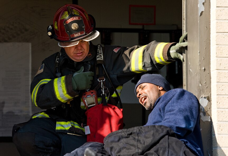 Aaron Weisenberger, left, 436th Civil Engineer Squadron Fire Department fire protection crew chief, makes a radio call about the status of simulated fuel spill victim Patrick Shaffer, right, TK&K fuel operator contractor, April 23, 2014, at Dover Air Force Base, Del. Weisenberger and Shaffer participated in a major accident response exercise that simulated a spill at the fuel storage area. (U.S. Air Force photo/Roland Balik)