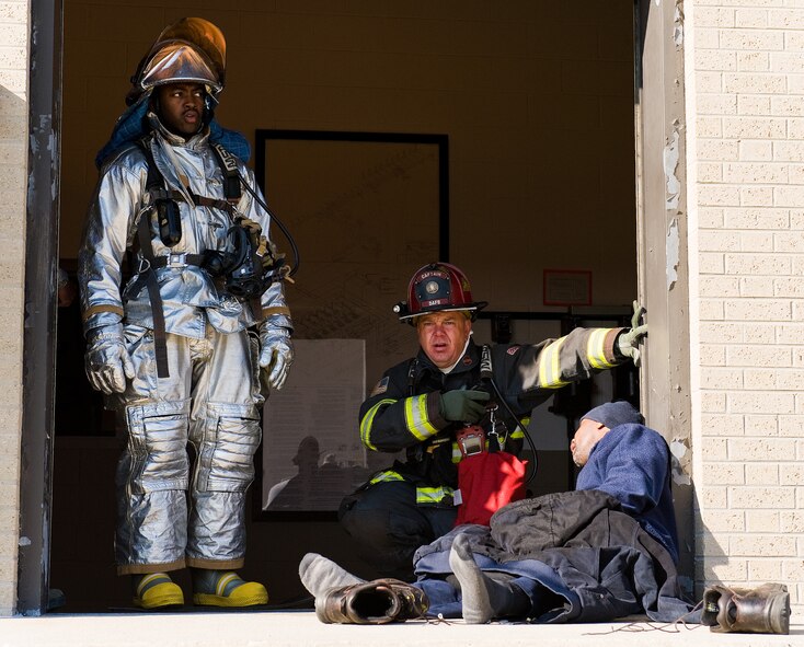 Senior Airman Dequan Griffin, left, a fire protection apprentice with the 459th Civil Engineer Squadron Fire Department, Joint Base Andrews, Md., and Aaron Weisenberger, center, a fire protection crew chief with the 436th Civil Engineer Squadron Fire Department, Dover Air Force Base, Del., give aid to Patrick Shaffer, right, TK&K fuel operator contractor, April 23, 2014, at Dover AFB. Shaffer simulated being drenched by Jet A fuel and was treated by first responders during a major accident response exercise. (U.S. Air Force photo/Roland Balik)