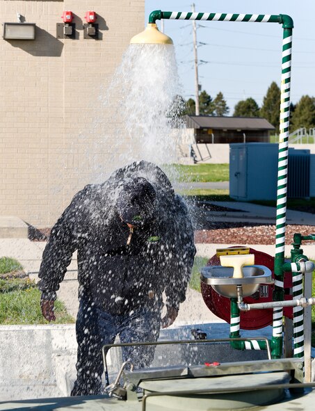 Patrick Shaffer, TK&K fuel operator contractor, walks through an emergency shower and eye wash station April 23, 2014, at Dover Air Force Base, Del. Shaffer simulated being drenched by Jet A fuel that required him to initiate an immediate washdown. (U.S. Air Force photo/Roland Balik)