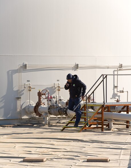 Patrick Shaffer, TK&K fuel operator contractor, runs away from a fuel storage tank while making a radio call April 23, 2014, at Dover Air Force Base, Del. Shaffer participated in a major accident response exercise that simulated a spill at the fuel storage area. (U.S. Air Force photo/Roland Balik)