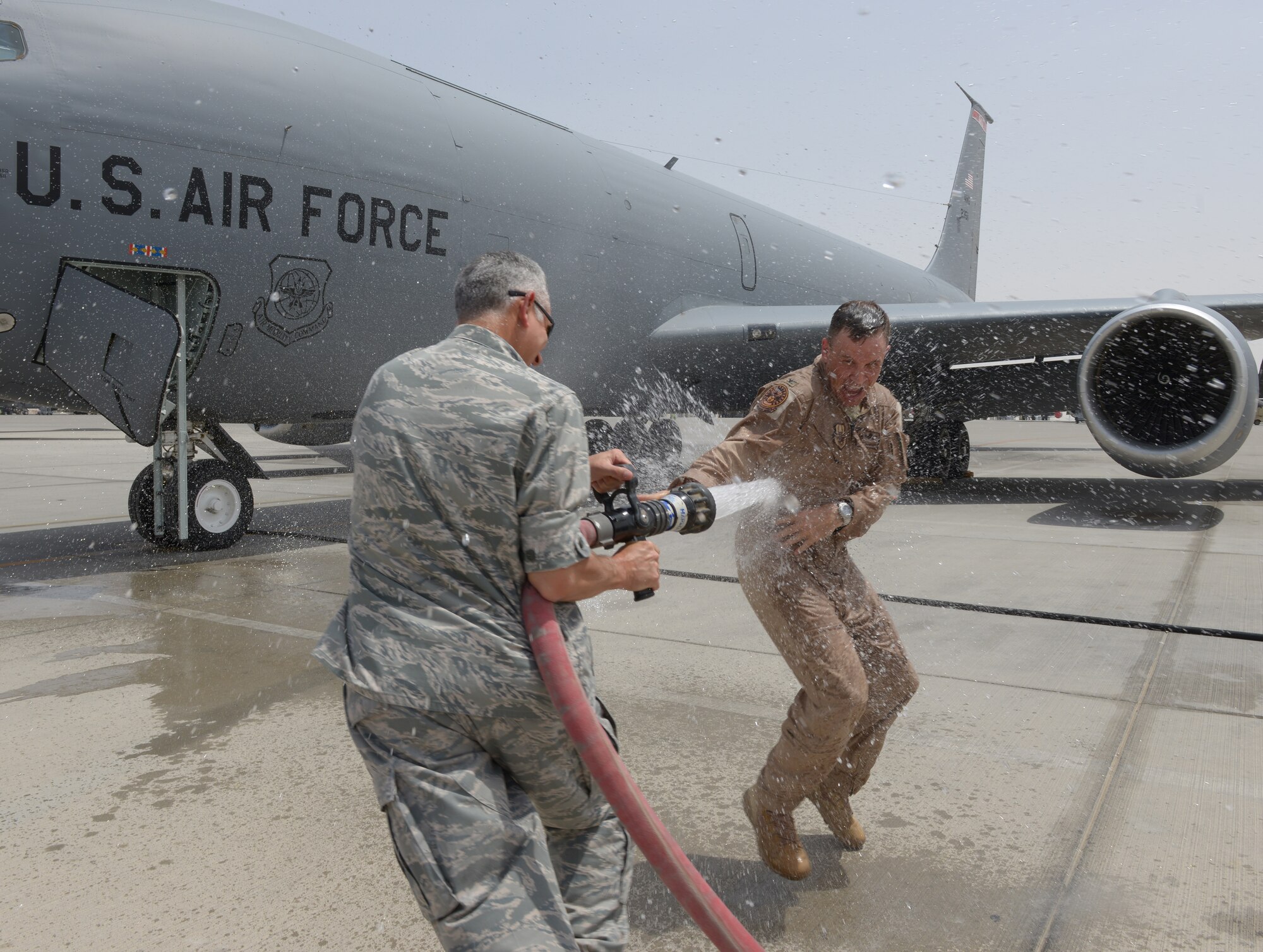 Col. John Lamontagne is sprayed by Brig. Gen. Roger H. Watkins during a fini-flight ceremony at Al Udeid Air Base, Qatar, April 23, 2014. Lamontagne is being fare-welled as the 379th Expeditionary Operations Group commander after a year tour at Al Udeid Air Base. As the 379th EOG commander, Lamontagne oversaw operations from airspace control, aeromedical evacuations, aerial refueling, combat aerial deliveries, operational airlift, intelligence and reconnaissance and close air support throughout the U.S. Central Command’s area of responsibility. Lamontagne hails from Springfield, V.A. and will be the wing commander for the 437th Airlift Wing at Joint Base Charleston, S.C. (U.S. Air Force photo/Senior Airman Hannah Landeros) 