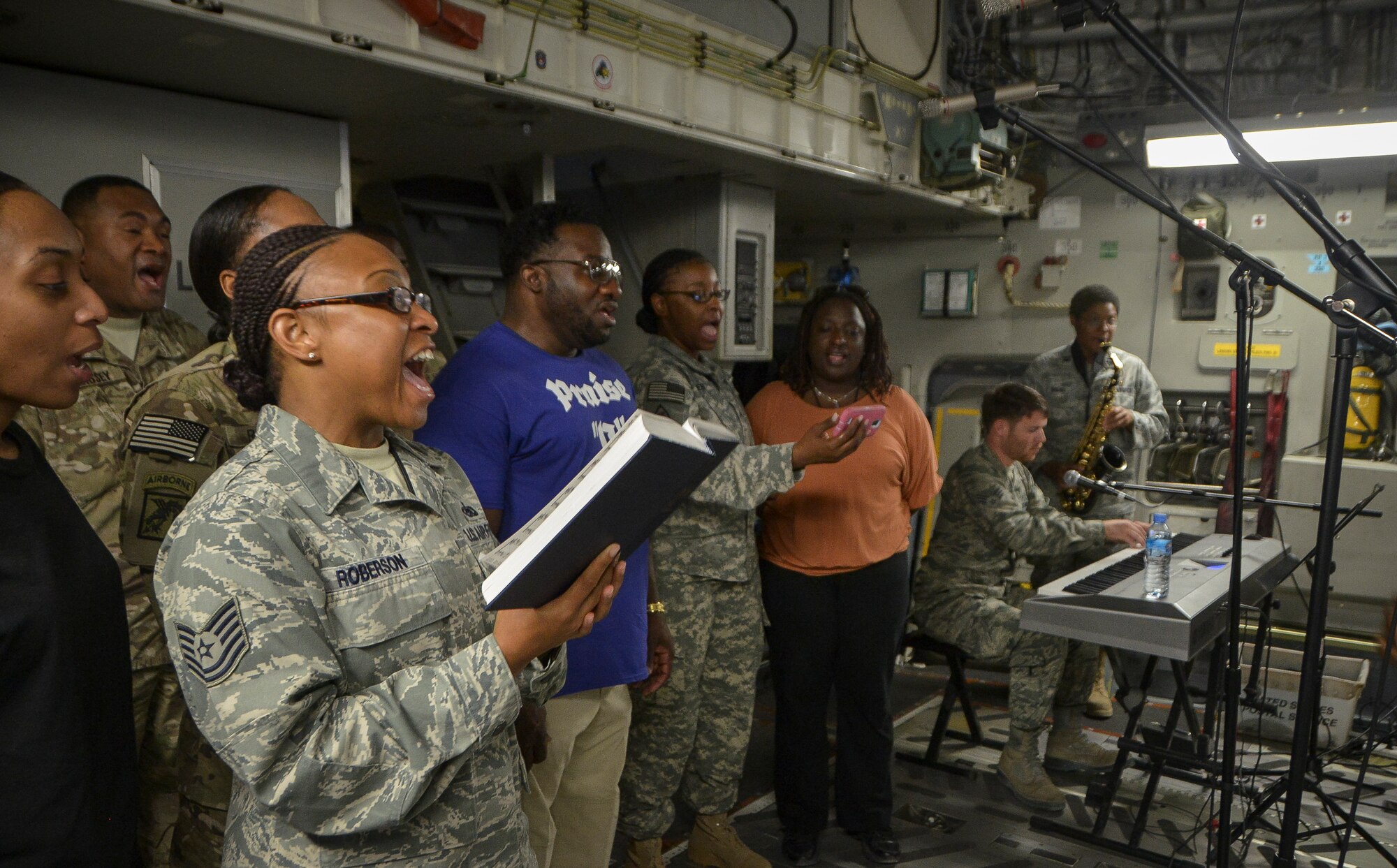Airmen Soldiers and civilians sing songs aboard a C-17 Globemaster III during an Easter Sunday service, at Al Udeid Air Base, Qatar, April 20, 2014. (U.S. Air Force photo/Senior Airman Jared Trimarchi) 