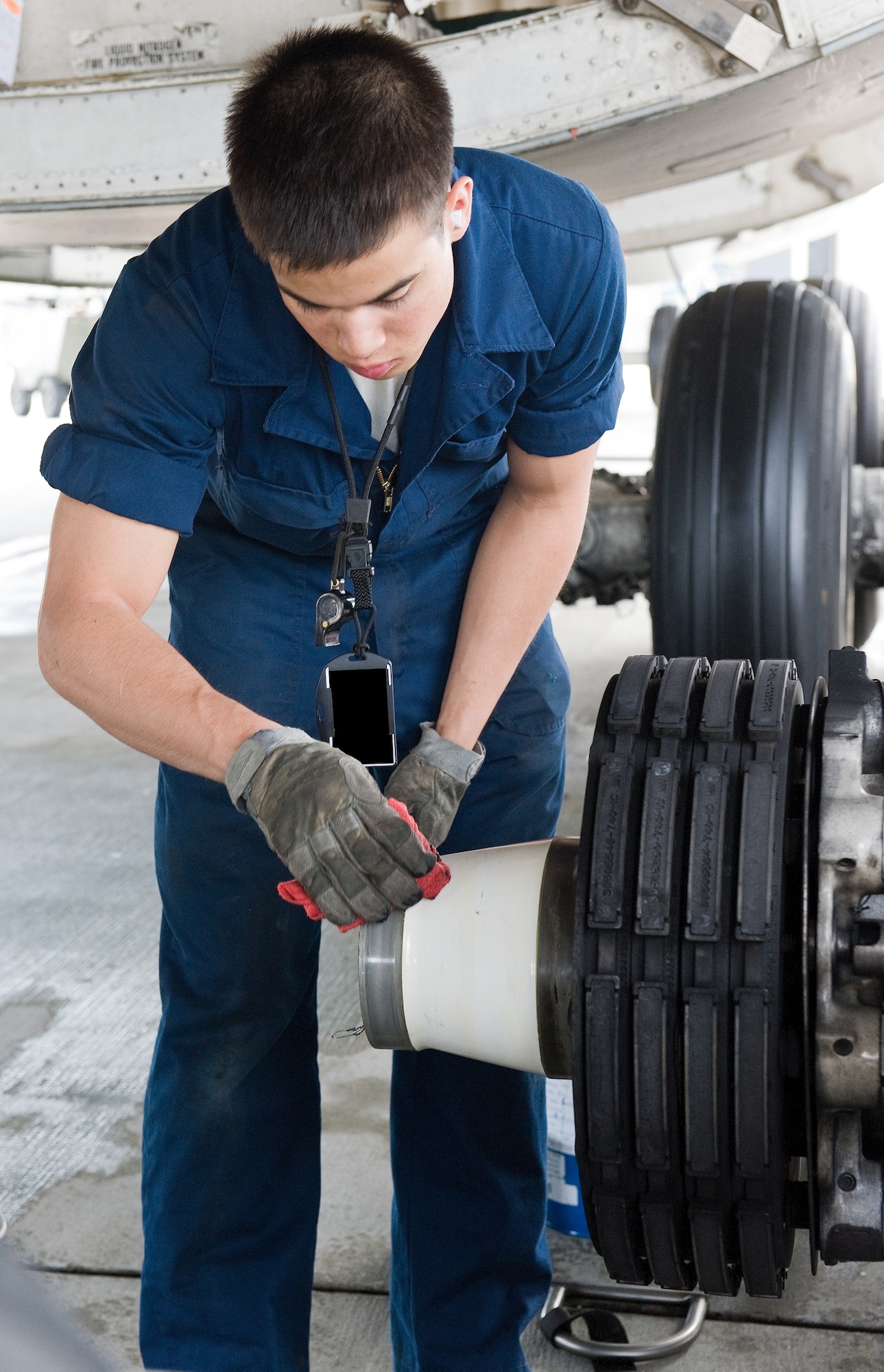Airman 1st Class Nathan Shull, 436th Aircraft Maintenance Squadron crew chief, cleans the number four main landing gear bogie assembly of a C-5M Super Galaxy April 22, 2014, at Dover Air Force Base, Del. Shull removed old lubricant after the 4A1 wheel and tire assembly was removed, then applied new lubricant prior to the installation of a new wheel and tire assembly. (U.S. Air Force photo by Roland Balik)
