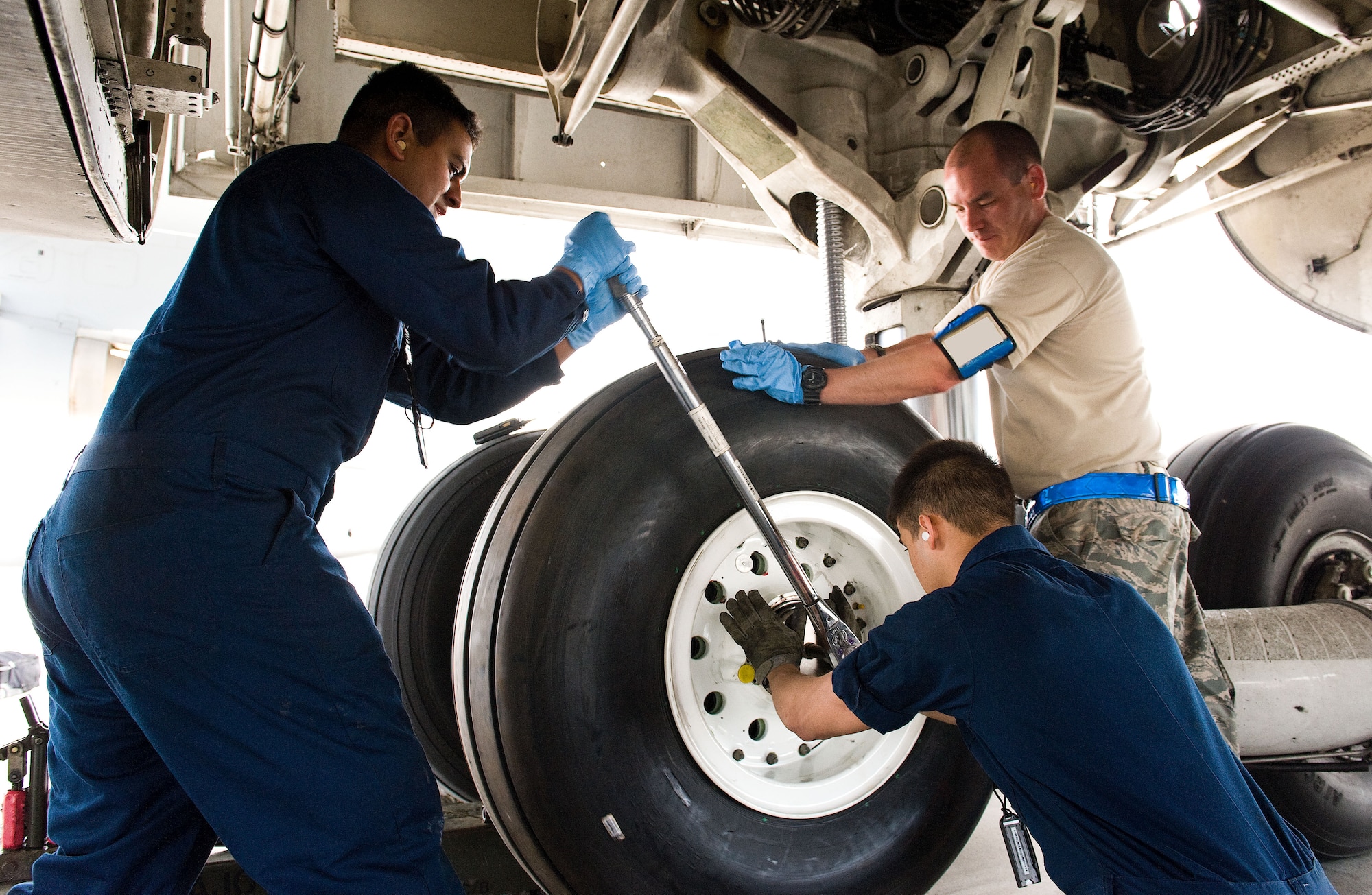 Airman 1st Class Vincent Gaspara, left, and Nathan Shull, center, and Tech. Sgt. Andrew Hamilton, right, all crew chiefs assigned to the 436th Aircraft Maintenance Squadron, secure a C-5M Super Galaxy main landing gear wheel and tire assembly to the main landing gear bogie April 22, 2014, at Dover Air Force Base, Del. The crew chiefs used a large torque wrench to apply specific torque values specified within the technical order covering a main landing gear wheel and tire change. (U.S. Air Force photo by Roland Balik)
