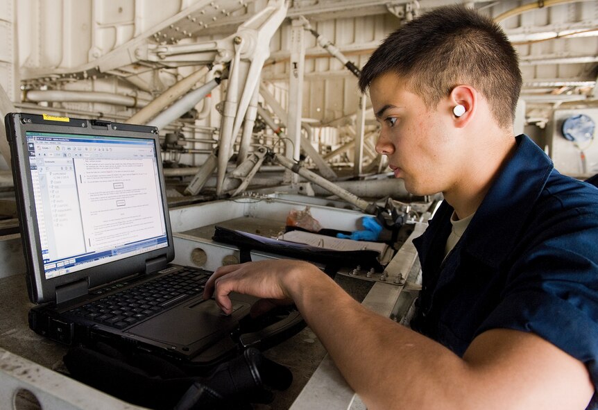 Airman 1st Class Nathan Shull, 436th Aircraft Maintenance Squadron crew chief, reviews the technical order for a C-5M Super Galaxy main landing gear tire change April 22, 2014, at Dover Air Force Base, Del. Shull assisted with the removal and replacement of the main landing gear wheel and tire assembly. (U.S. Air Force photo by Roland Balik)