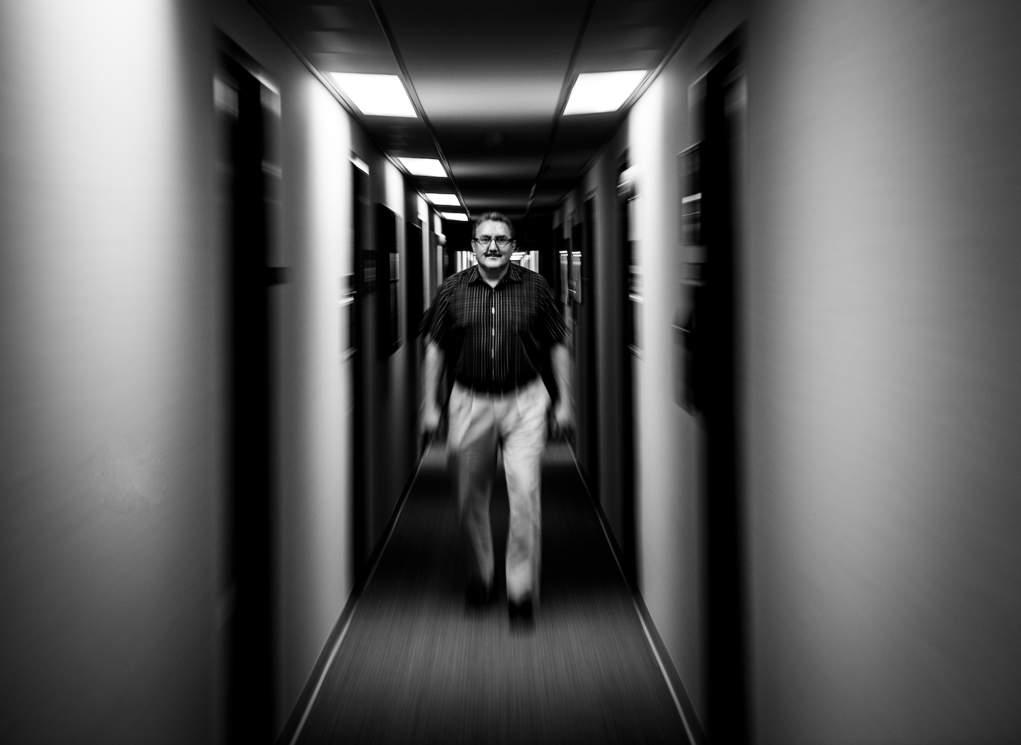Jason Axberg, 628th Air Base Wing historian, walks down the hall to his office where he not only writes the current history, but also researches prior histories April 22, 2014. (U.S. Air Force photo/ Senior Airman Dennis Sloan)