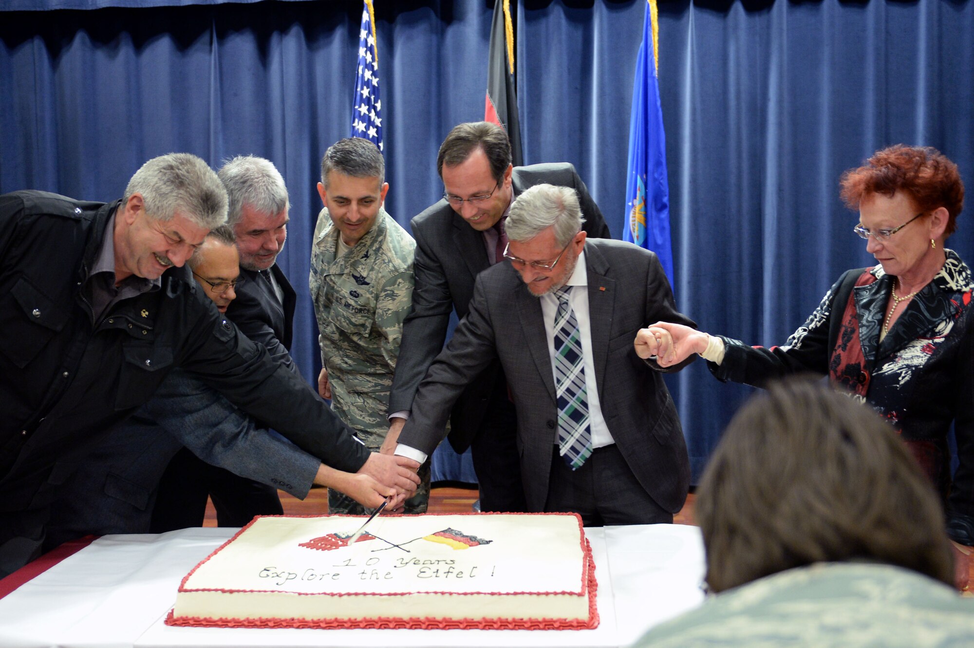 U.S. Air Force Col. David Julazadeh, 52nd Fighter Wing commander, and local German community leaders cut a cake kicking off the 10th Annual Explore the Eifel Info and Adventure Fair at Club Eifel on Spangdahlem Air Base, Germany, April 24, 2014. The included live music, a children’s art show, archery, live animals, dancers and free gifts.  (U.S. Air Force photo by Senior Airman Alexis Siekert/Released)