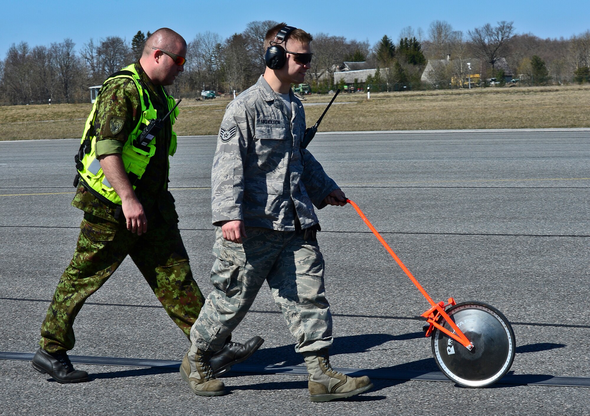 U.S. Air Force Staff Sgt. Josh Nicholson, 48th Air Expeditionary Group aircraft arresting systems craftsman and Estonian air force Master Sgt. Oleg Tsakuhhin, measure the pull out length of the purchase tape after a certification barrier engagement at Amari Air Base, Estonia, April 22, 2014. Members of the 48th AEG recently took a trip to Amari AB to engage and certify the aircraft arresting system, taking a critical step toward validating the new NATO Forward Operating Base. (U.S. Air Force photo by Airman 1st Class Dana J. Butler/Released)