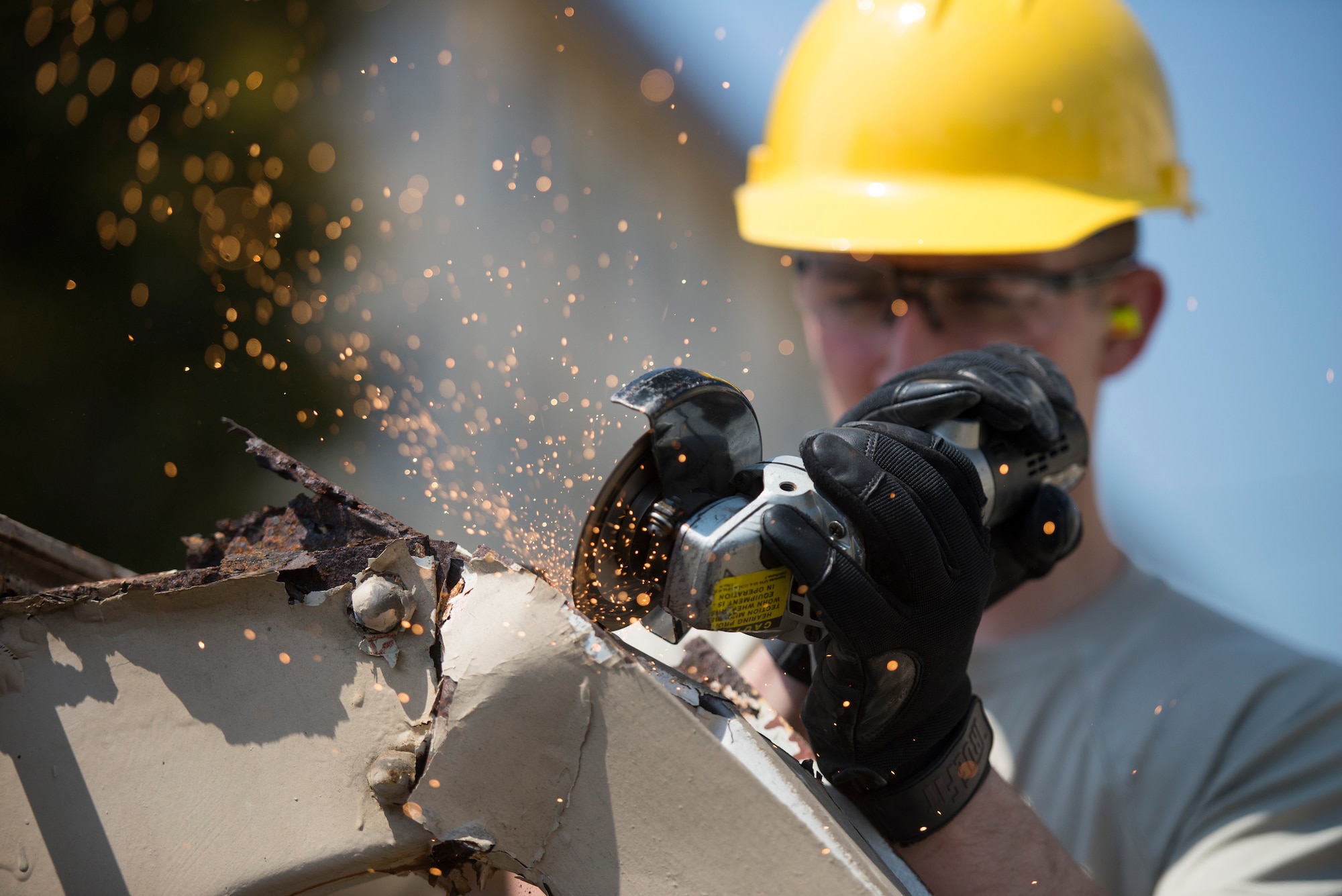 Airman 1st Class Alex Redden, 374th Civil Engineer Squadron structures journeyman, cuts through a corroded support beam while removing a damaged roof at Yokota Air Base, Japan, April 24, 2014. The roof, which was damaged in the winter during heavy snowfall, was removed to prevent possible injury and allow dormitory residents access to their bicycle lot. (U.S. Air Force photo by Staff Sgt. Cody H. Ramirez/Released)