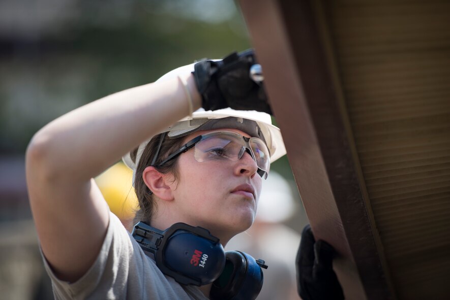 Senior Airman Kristen DiBennedetto, 374th Engineer Squadron structures journeyman, loosens a bolt from a damaged roof segment at Yokota Air Base, Japan, April 24, 2014. The winter’s heavy snowfall caused the roof to cave in which has since blocked dormitory resident’s access to their bicycle lot. (U.S. Air Force photo by Staff Sgt. Cody H. Ramirez/Released)